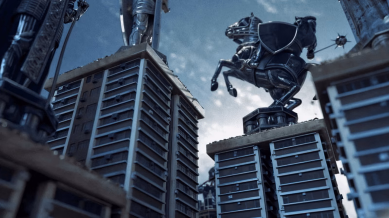 Be Ekhtesar low-angle 3D view of oversized metallic chess figures standing on high-rise buildings.
