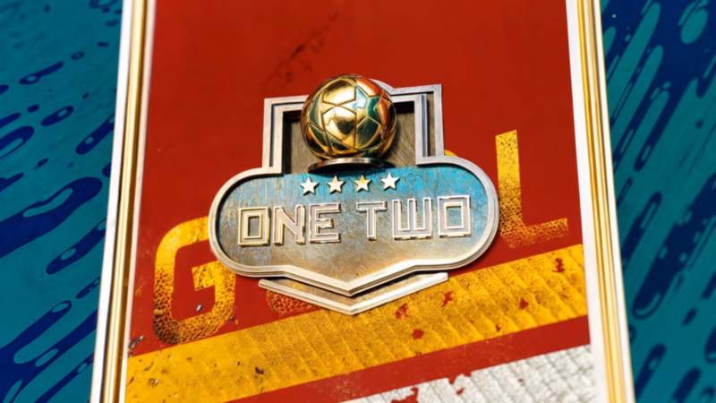 Metallic One Two programme badge topped by a golden football and four stars on a red and gold panel.