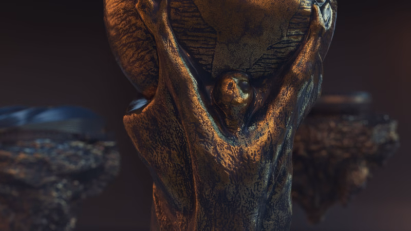 Close-up of the weathered bronze World Cup trophy with rocky platforms behind in the Qatar 2022 artwork