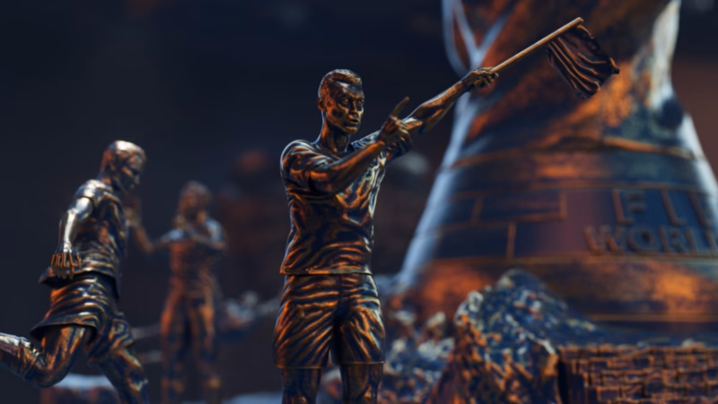 Bronze assistant referee raising a flag beside footballer sculptures and a giant trophy in the Qatar 2022 broadcast artwork